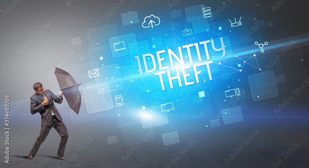 Businessman defending with umbrella from cyber attack and IDENTITY THEFT inscription, online security concept Businessman defending with umbrella from cyber attack and IDENTITY THEFT inscription, online security concept