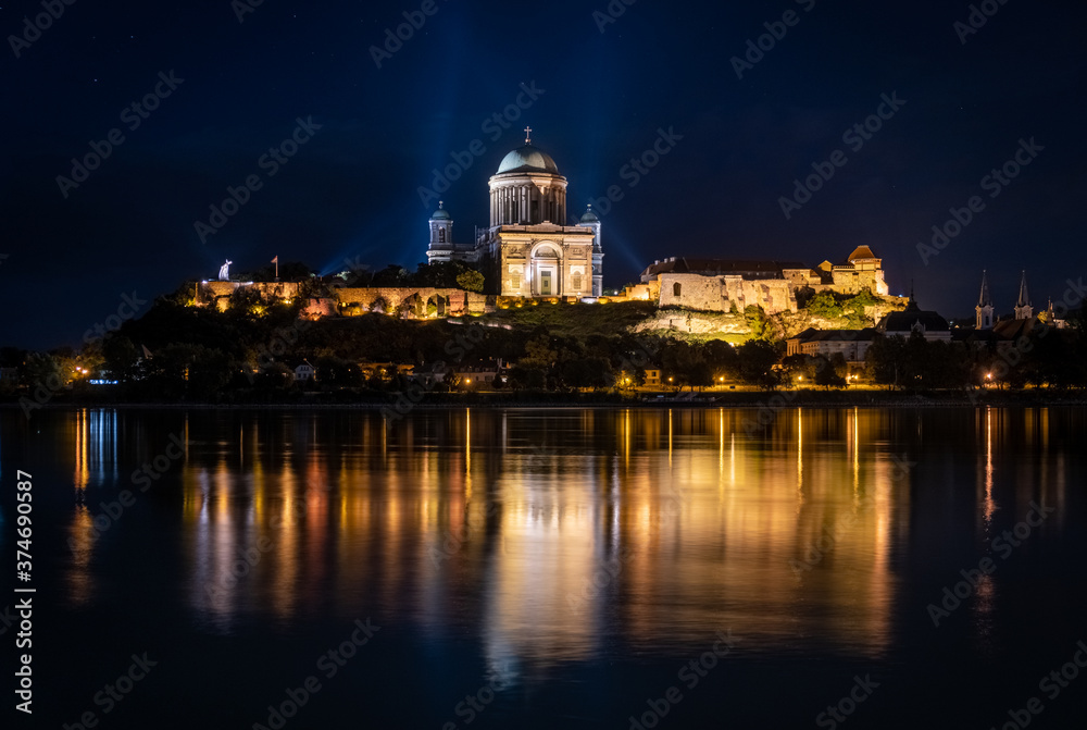 Castle Hill of Esztergom basilica night photo. Reflection in water. Stars and light