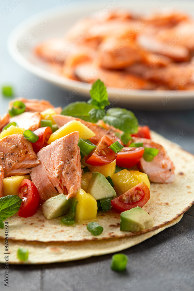 Salmon fish tacos with mango, avocado, tomato, spring onion and lime. Mexican food Salmon fish tacos with mango, avocado, tomato, spring onion and lime. Mexican food