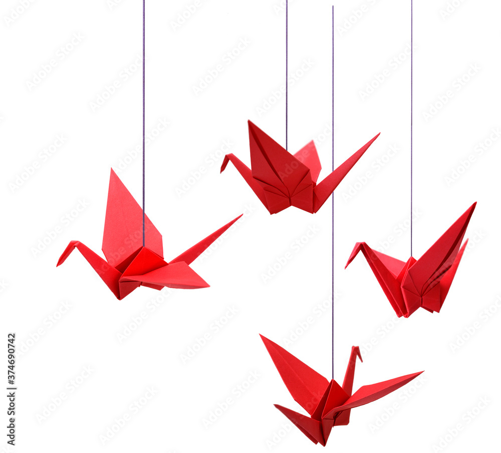 Red origami paper cranes handing on with string Stock Photo