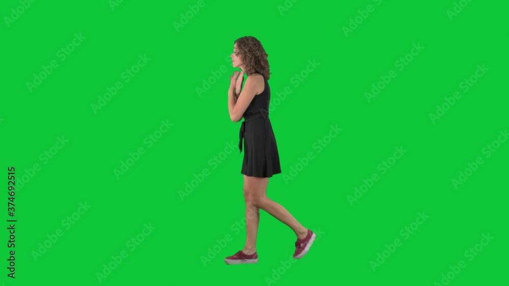 Angry young woman walking and yelling while arguing. Full body side view on green screen chroma key background. Angry young woman walking and yelling while arguing. Full body side view on green screen chroma key background.