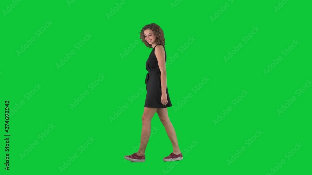 Amazed young walking woman looking around at shopping discounts. Full body side view on green screen chroma key background. Amazed young walking woman looking around at shopping discounts. Full body side view on green screen chroma key background.
