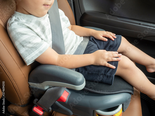シートベルトをしてチャイルドシートに座る子供