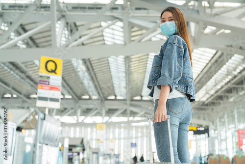 asian female traveller casual cloth wear face mask protection hand pull luggage in airoirt departure terminal safety travel concept © whyframeshot