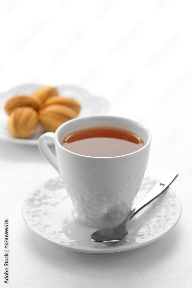 Close up view of dessert plate and cup of tea on white background Close up view of dessert plate and cup of tea on white background