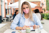 Business woman at cafe wearing face protective mask