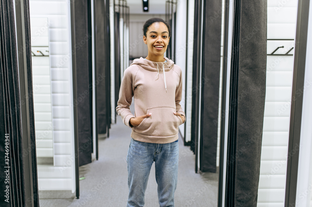 Woman standing in fitting room, clothing store