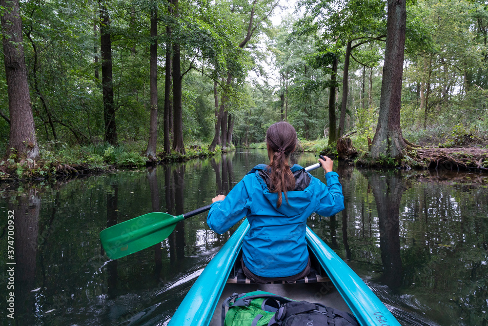 female kayaker enjoys paddling through the channels and canals o the Spreewald region in Germany female kayaker enjoys paddling through the channels and canals o the Spreewald region in Germany