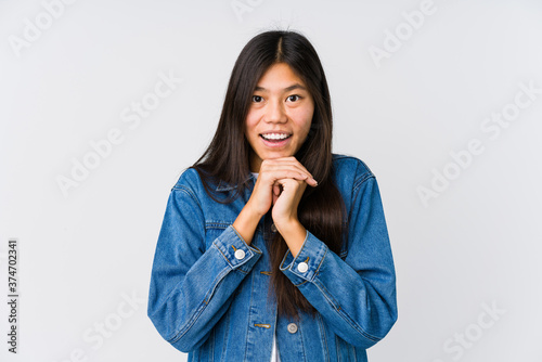 Young asian woman praying for luck, amazed and opening mouth looking to front.