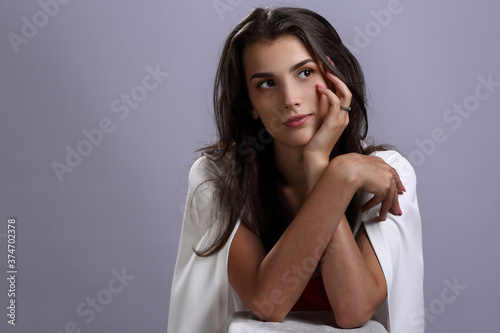 Beautiful girl in a white Cape on a gray background
