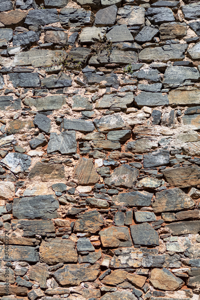 View of a rustic and old schist exterior wall, architectural textures, detailed wall masonry schist