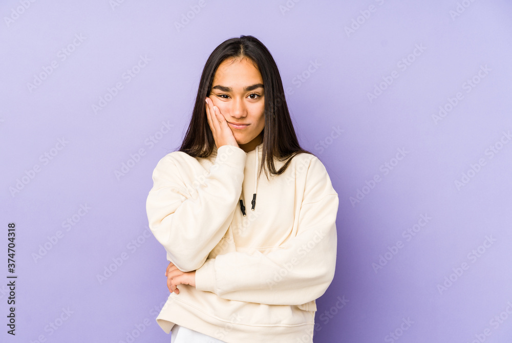 Young woman isolated on a purple background who is bored, fatigued and need a relax day. Young woman isolated on a purple background who is bored, fatigued and need a relax day.