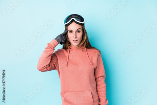 Young skier woman isolated showing a disappointment gesture with forefinger.