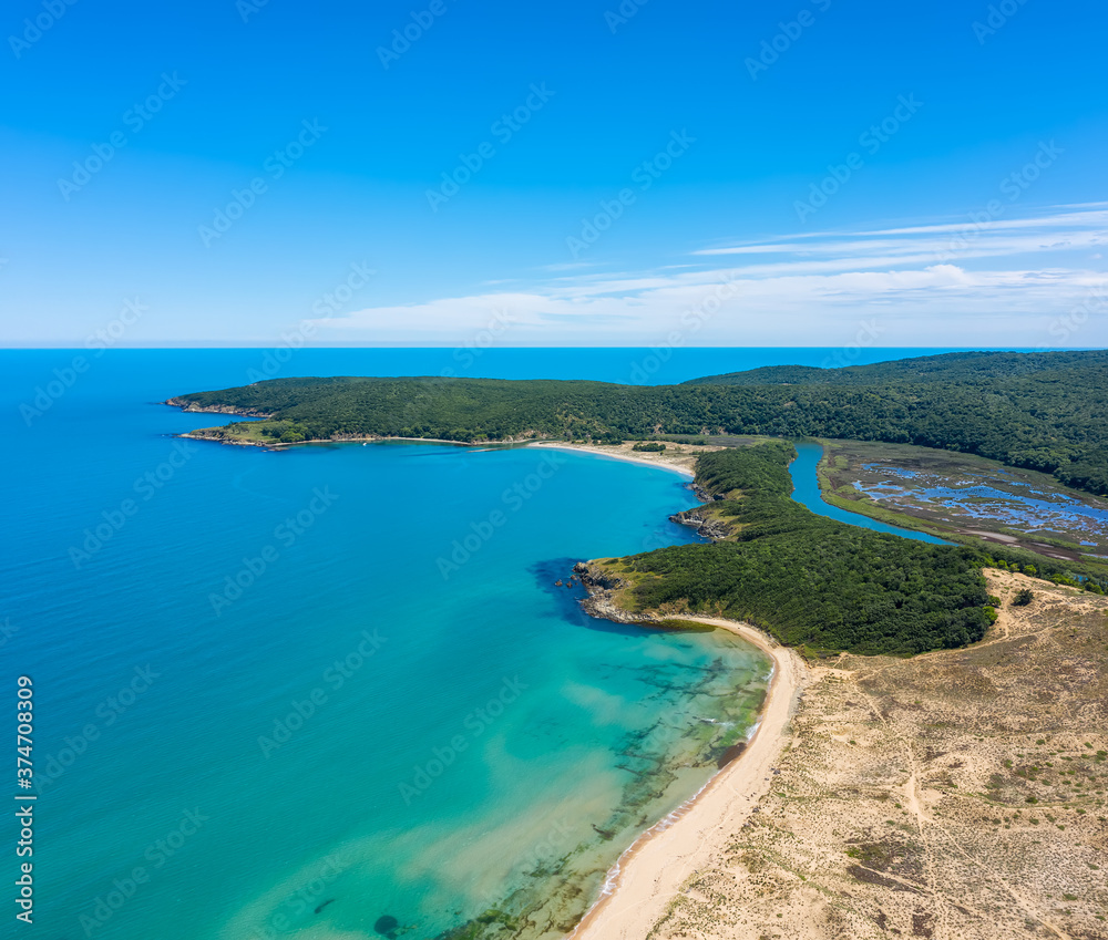 Fototapeta premium Aerial view of the picturesque curves of a river among lush vegetation that flows into the sea, Ropotamo River in Ropotamo Nature Reserve, Strandzha Mountain