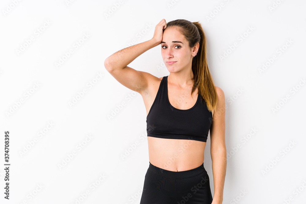 Young caucasian fitness woman posing in a white background being shocked, she has remembered important meeting. Young caucasian fitness woman posing in a white background being shocked, she has remembered important meeting.