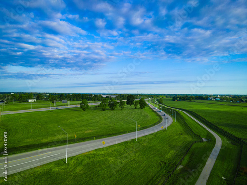Fototapeta Naklejka Na Ścianę i Meble -  Highway next to meadows and fences of horse farms in rural Kentucky, USA