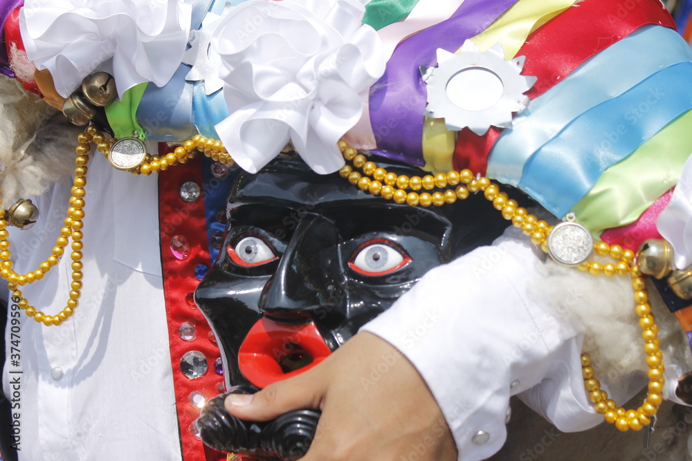 fingers of the hand holding a mask of the Mexican culture purepecha handicrafts from Michoacán