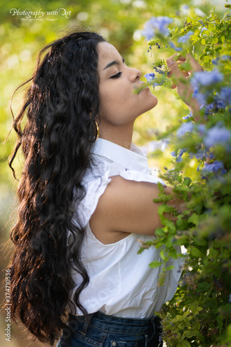 Mujer oliendo las flores cojiendola con su mano
