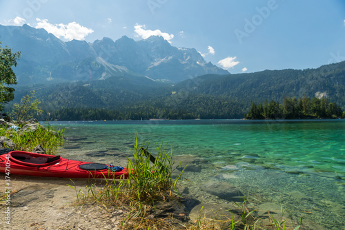 A red kayak at the Eibsee in front of the Zugspitze mountain