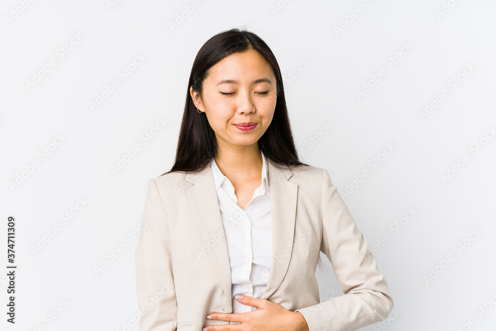 Young chinese business woman isolated touches tummy, smiles gently, eating and satisfaction concept. Young chinese business woman isolated touches tummy, smiles gently, eating and satisfaction concept.
