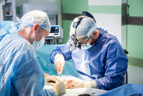 Surgeons in the operating room trying to save the patient's hand.