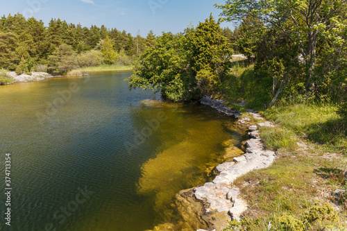 Old stone quarry filled with emerald water. Saaremaa island, Estonia. © yegorov_nick