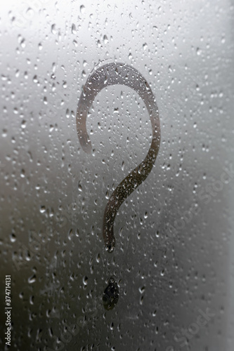 Question mark written by a finger on a misted glass.