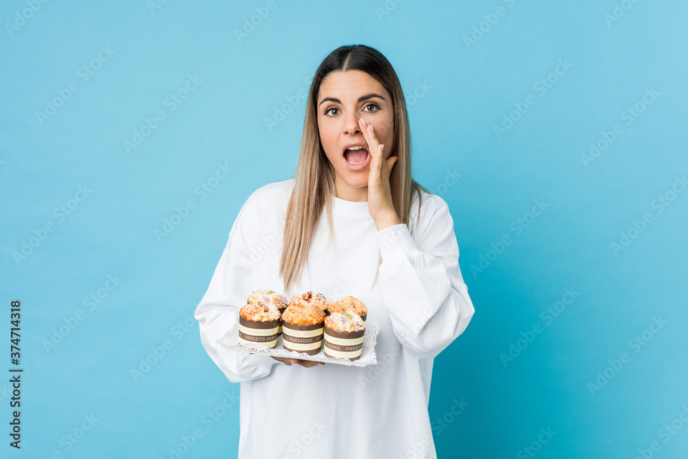 Young caucasian woman holding a sweets cake shouting excited to front. Young caucasian woman holding a sweets cake shouting excited to front.
