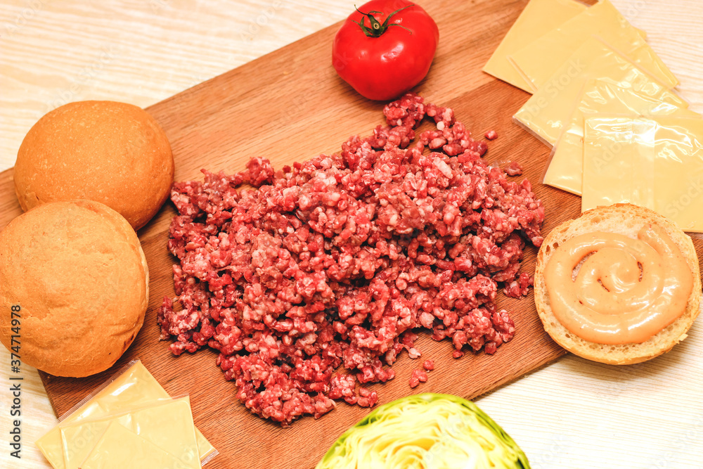 Fresh minced meat for making a burger at home. Ingredients for a homemade cheeseburger.