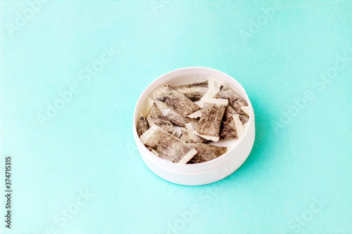 Round box with snus. Cigarette substitute, nicotine pouches. photo