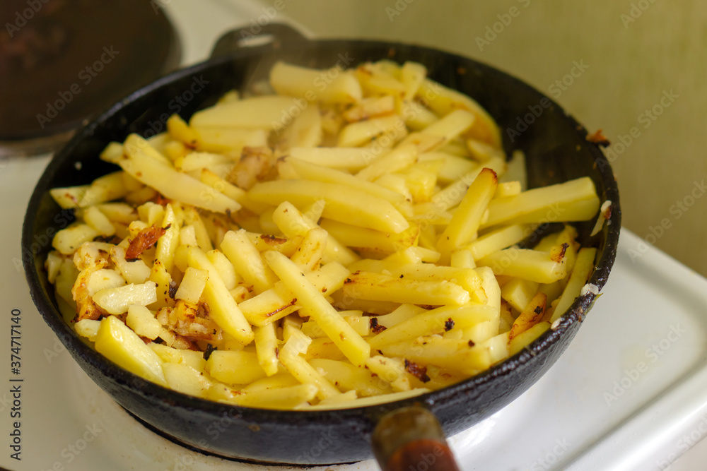 The potatoes are fried in a black cast-iron skillet. The potatoes are fried in a black cast-iron skillet.