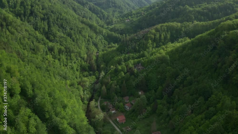 Drone flight above green tree-covered mountain slopes and houses nestled in them, the Balkan Mountains, Bulgaria Drone flight above green tree-covered mountain slopes and houses nestled in them, the Balkan Mountains, Bulgaria