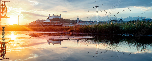 view of Bratislava castle on late afternoon in water pool with the ricochet and beautiful sunset on river Danube, Slovakia