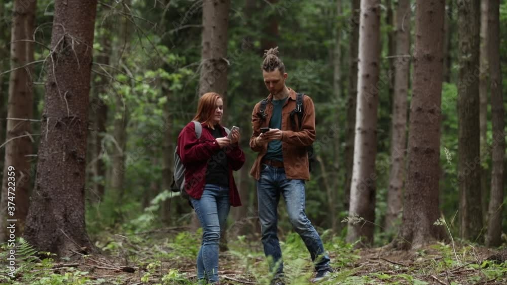 young couple is looking for a mobile connection in the forest