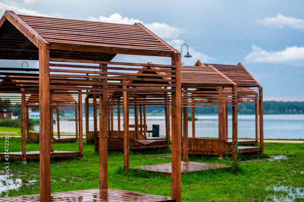 wooden deck chairs on the beach. on the horizon is a lake and a forest. after the rain everything is wet, on the ground puddles wooden deck chairs on the beach. on the horizon is a lake and a forest. after the rain everything is wet, on the ground puddles