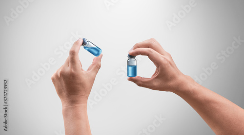 Doctor hands inspecting medical drug. Bright grey background. Medical concept for health care, reseach, and science.