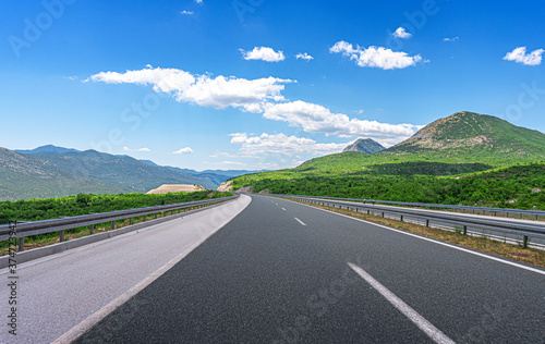 Mountain highway with blue sky and rocky mountains on a background