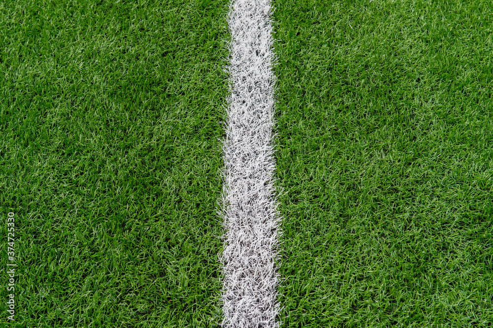Fototapeta premium Green synthetic grass sports field with white line shot from above. Soccer, rugby, football, baseball sport concept