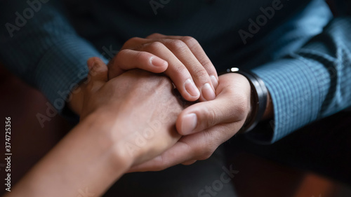 Close up African American man comforting woman, holding hands, expressing love and support, empathy, apologizing or saying sorry, family reconciliation, understanding in relationship
