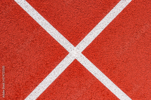Close up on a white line in artificial red turf, on a street basketball, handball, volleyball, futsal, rugby, hockey and football field, in a sports background © Augustas Cetkauskas