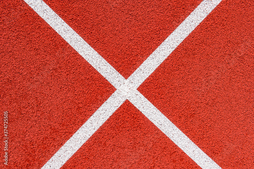 Close up on a white line in artificial red turf, on a street basketball, handball, volleyball, futsal, rugby, hockey and football field, in a sports background