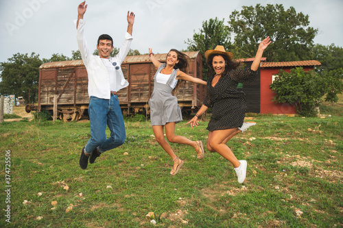 Three Friends Jumping, Laughing and Having Fun in the Ranch