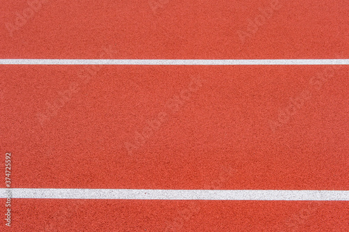 Close up on a white line in artificial red turf, on a street basketball, handball, volleyball, futsal, rugby, hockey and football field, in a sports background