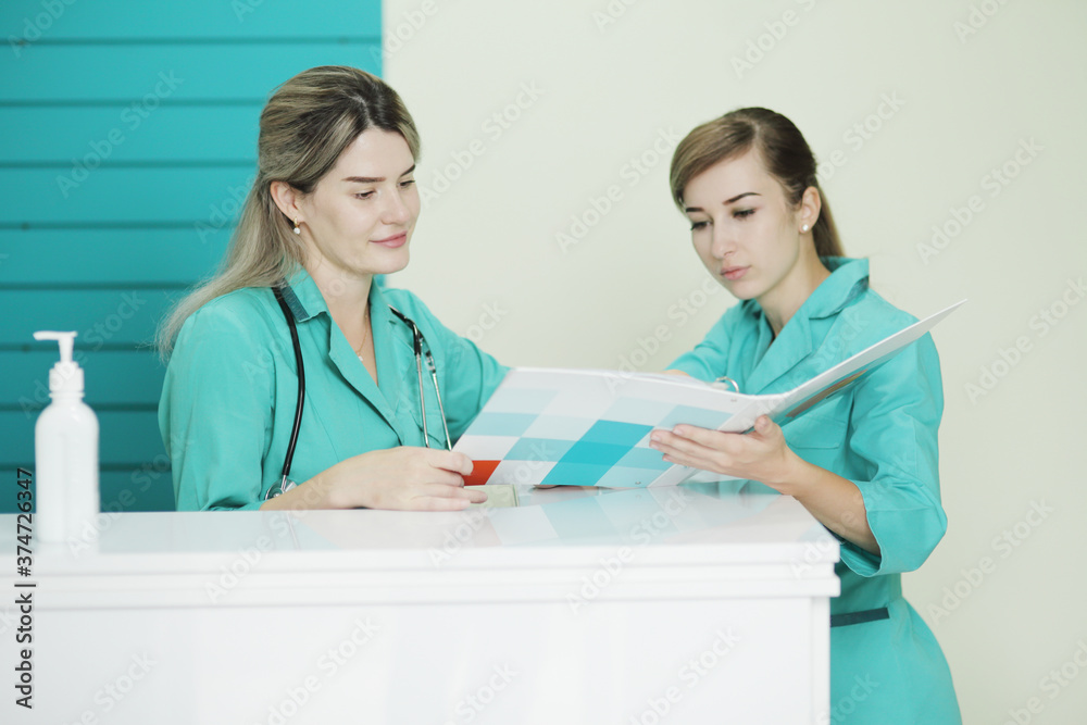 Two female doctor or nurse discussing patient treatment. Stethoscope on the neck Two female doctor or nurse discussing patient treatment. Stethoscope on the neck