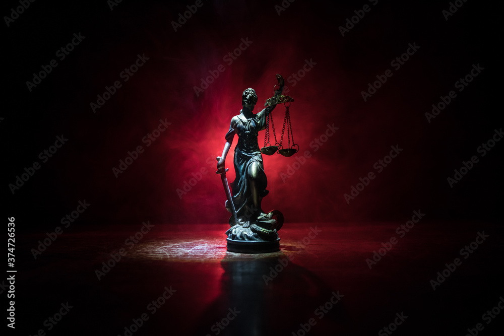 The Statue of Justice - lady justice or Iustitia / Justitia the Roman goddess of Justice on a dark fire background The Statue of Justice - lady justice or Iustitia / Justitia the Roman goddess of Justice on a dark fire background