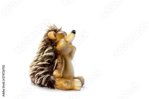 Fototapeta Naklejka Na Ścianę i Meble -  Isolated ceramic toy for children pensive hedgehog sitting side view on white background space for text