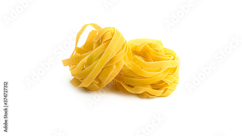Uncooked fettuccine nest pasta on white background. High quality photo