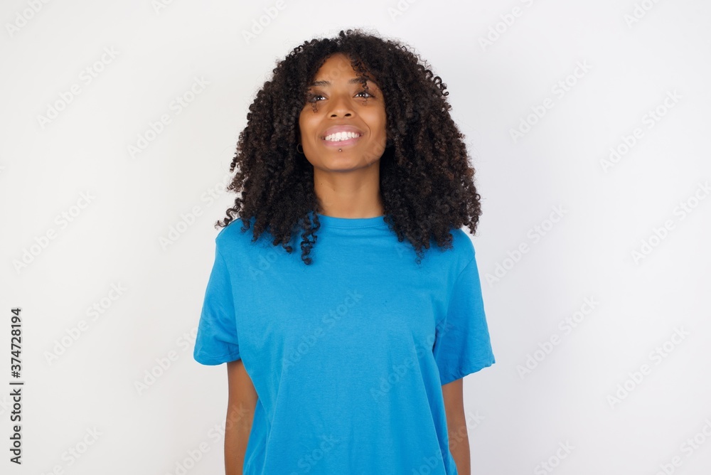 Young african woman with curly hair wearing casual blue shirt over white background with a happy and cool smile on face. Lucky person. Young african woman with curly hair wearing casual blue shirt over white background with a happy and cool smile on face. Lucky person.