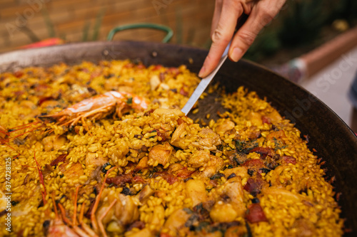 Young woman serving a serving of typical Spanish seafood paella