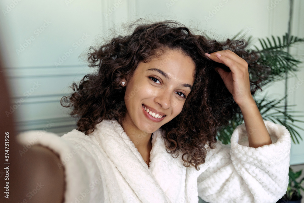 Young adult afro american woman in bathrobe making self portrait Young adult afro american woman in bathrobe making self portrait